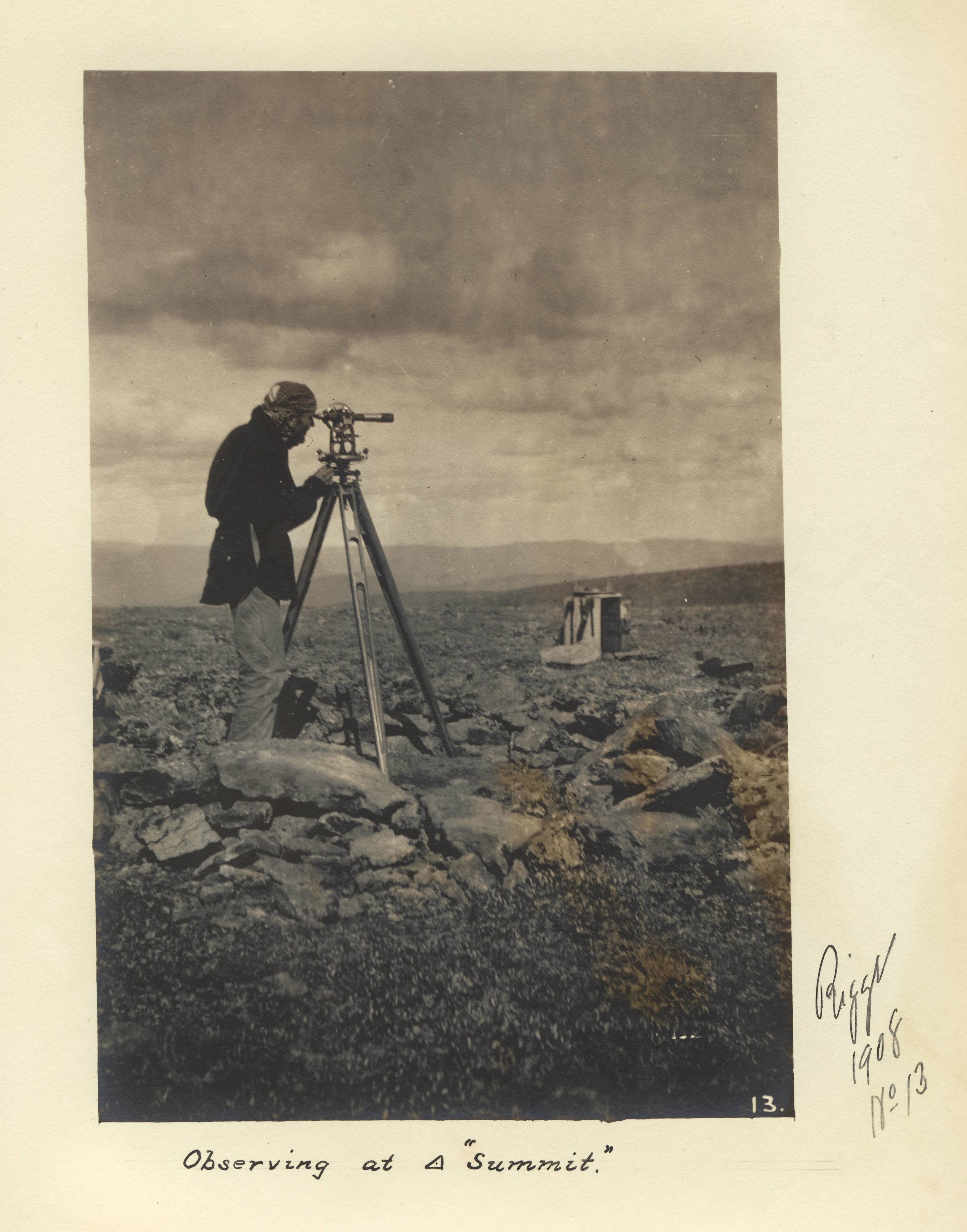 photo of a man looking through a scope on rocky terrain