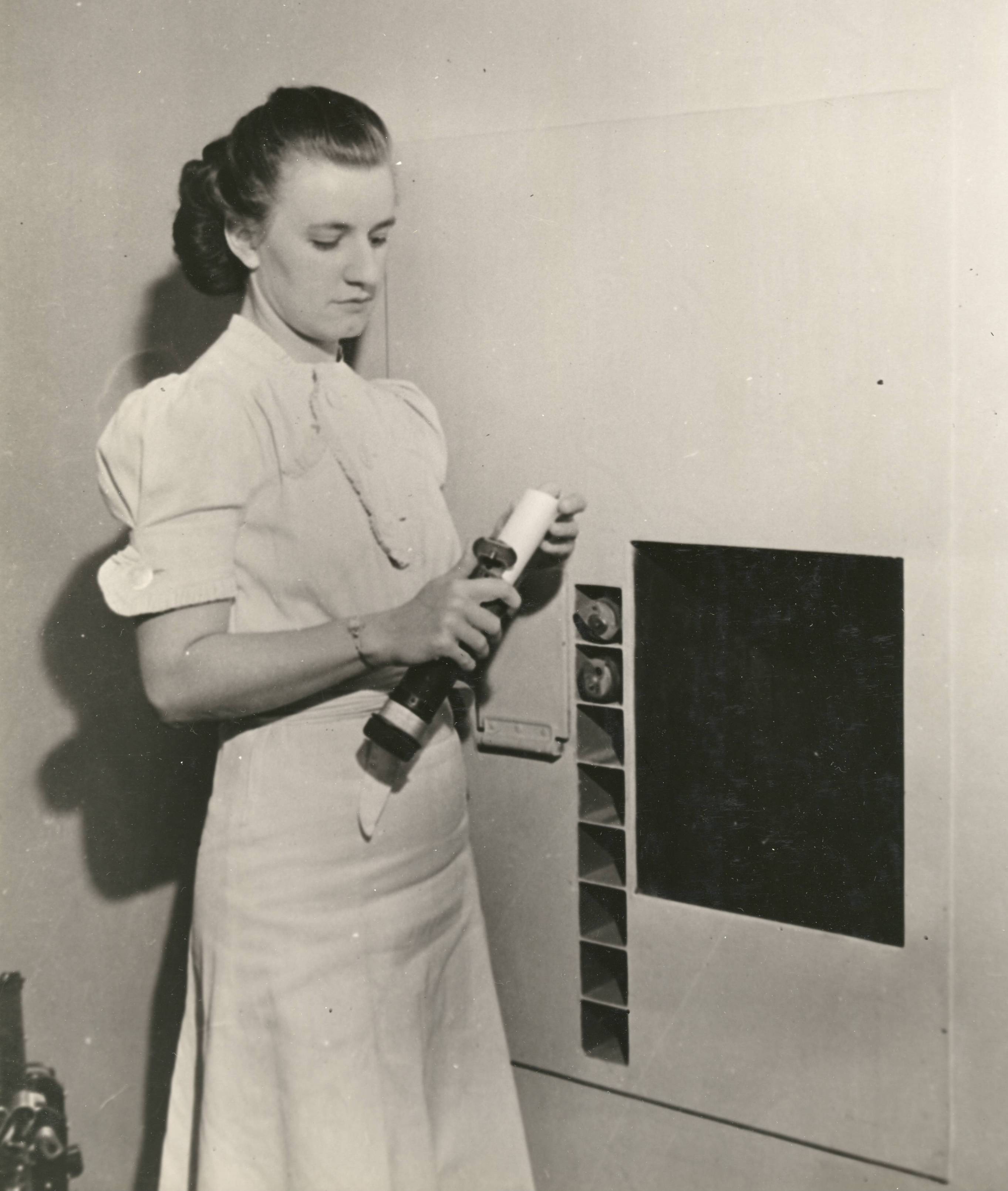64-NA-340 Edith Houbert Retrieves Request from Pneumatic Tube, 1940 - cropped