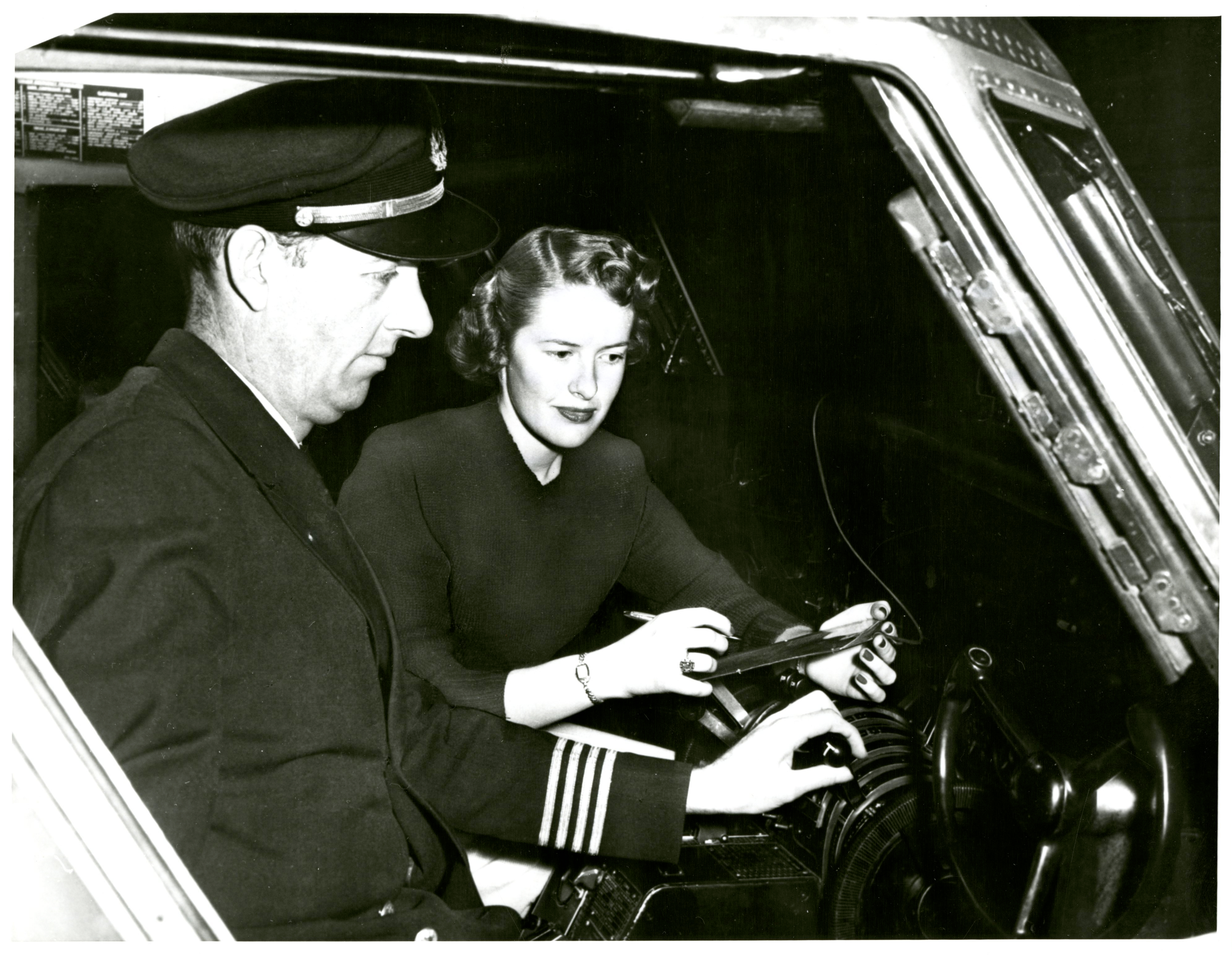 A stewardess and pilot in the cockpit.