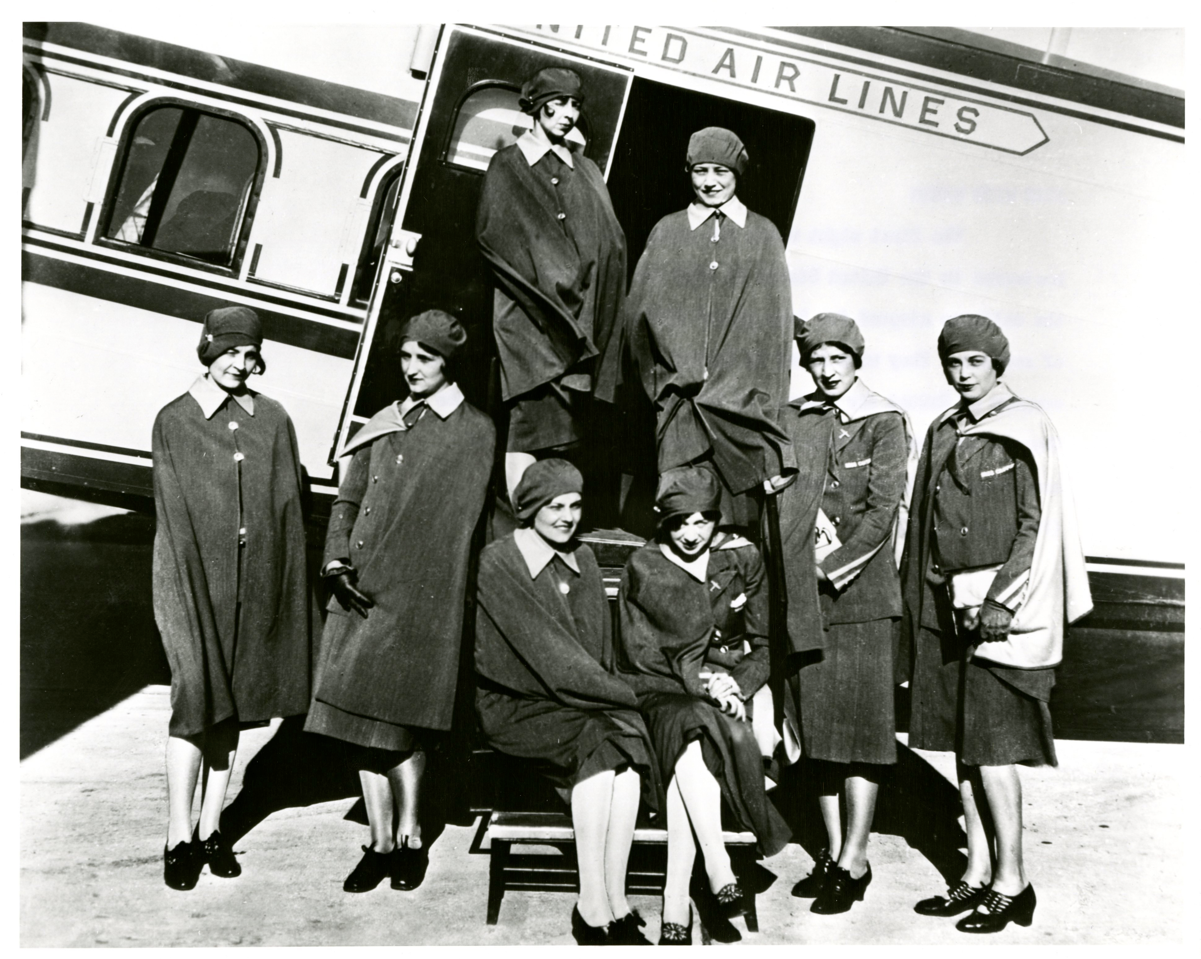 Stewardess posing outside an airplane.