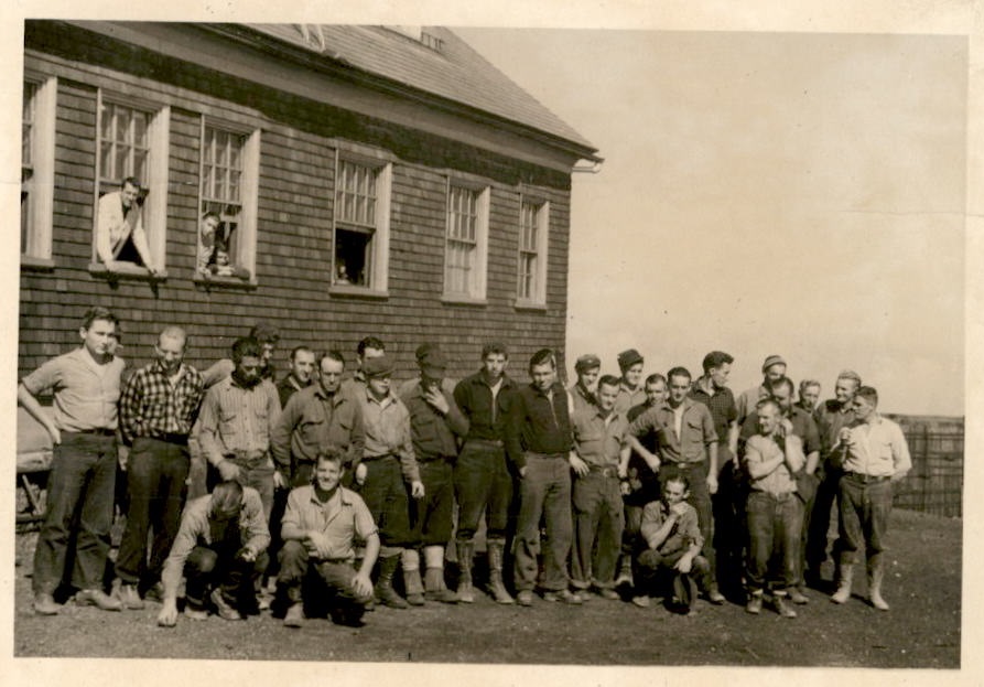 Image of men posing for the camera outside a building.