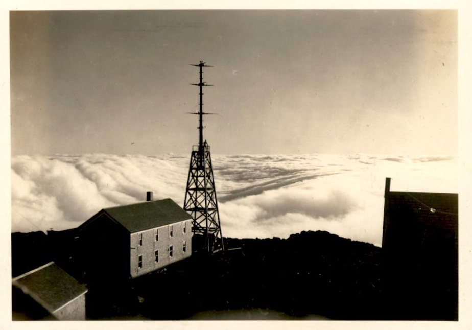 Image of tower and other buildings with clouds in the background