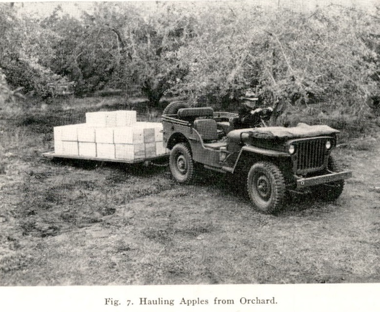 picture of a jeep towing a flatbed stacked with apples
