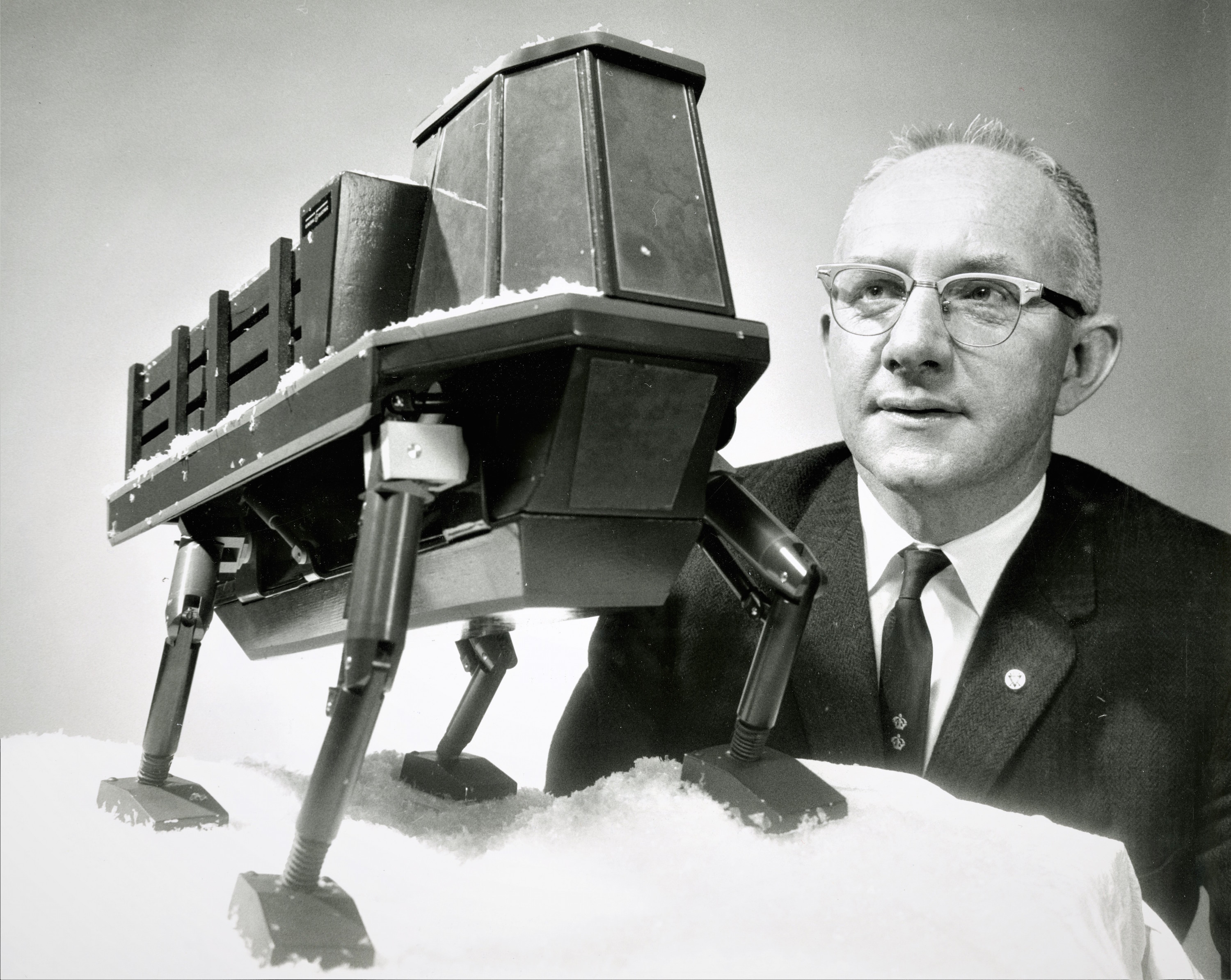 photograph of man, Ralph S. Mosher, looking at a quadruped model.