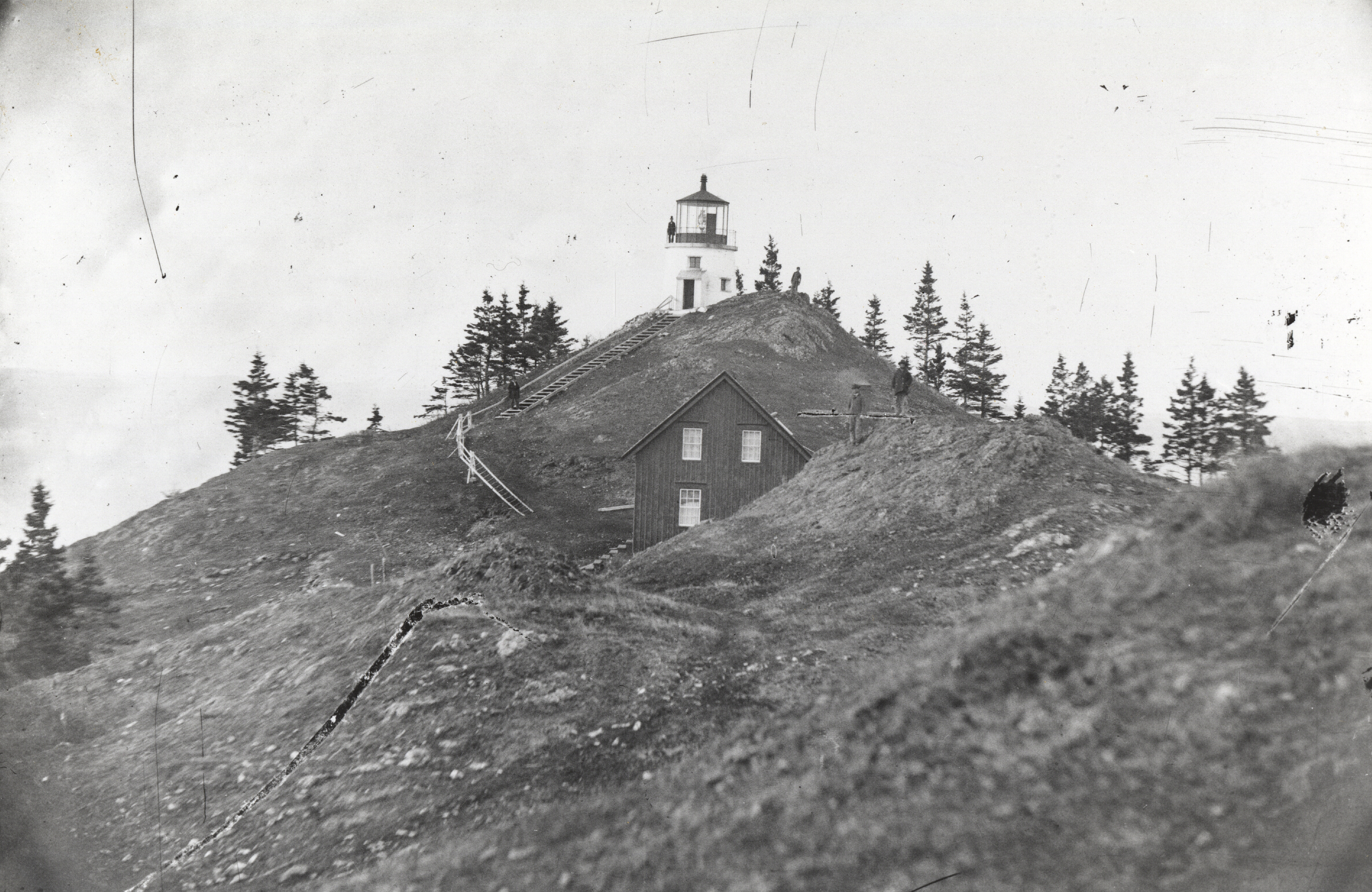 Image of a hill with a lighthouse and cabin.